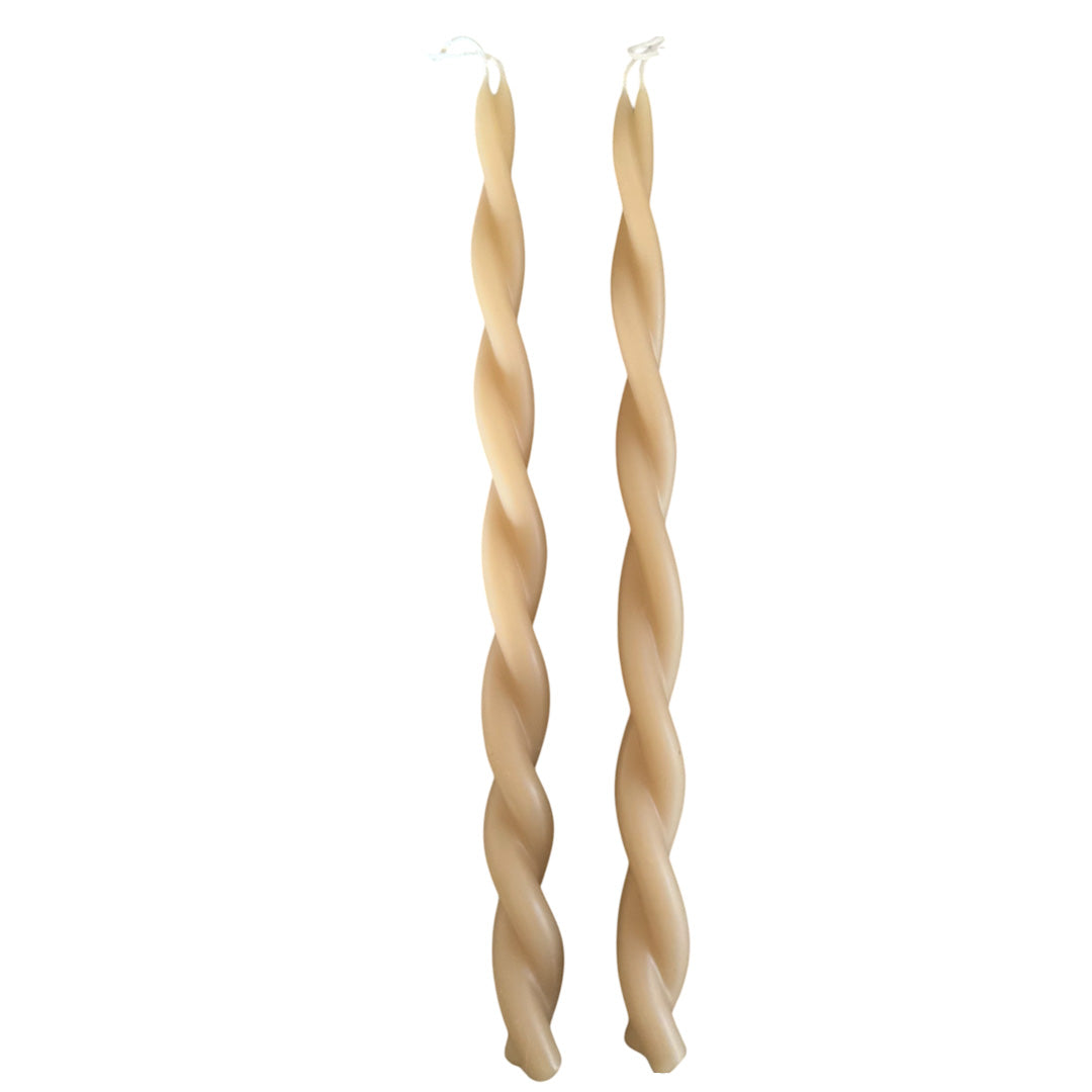 A pair of GLŌAM hand-twisted beeswax candles in marzipan beige, crafted with plant-based pigments.
