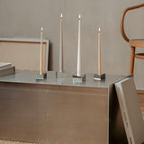 The Reflector, minimalist, modern candle holders Designed by STOFF Nagel, Grouped together small and large creating  grouped together a movement of light and rythm.
