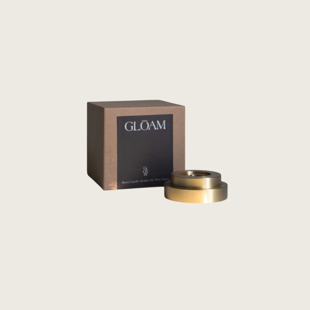 GLŌAM thin taper golden brass holder, a sculptural minimalist brass base made for Thin beeswax tapers, solid polished brass, packaged in a gift box.