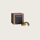 GLŌAM thin taper golden brass holder, a sculptural minimalist brass base made for Thin beeswax tapers, solid polished brass, packaged in a gift box.