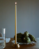 GLŌAM thin taper golden brass holder, a sculptural minimalist brass base made for Thin refined beeswax tapers. solid polished brass.