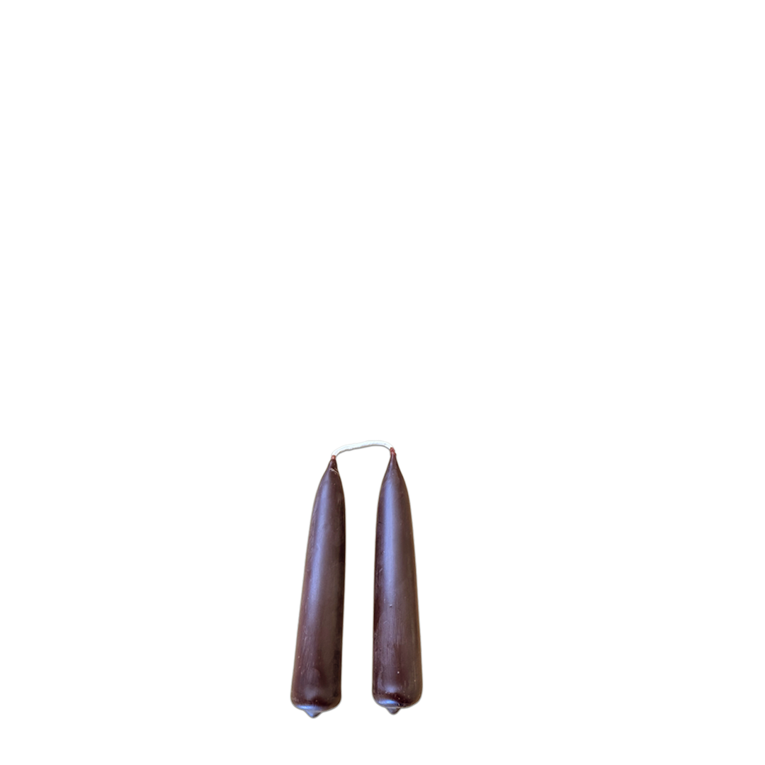 A pair of dripless beeswax mini taper candles in creme de cassis, brown hue