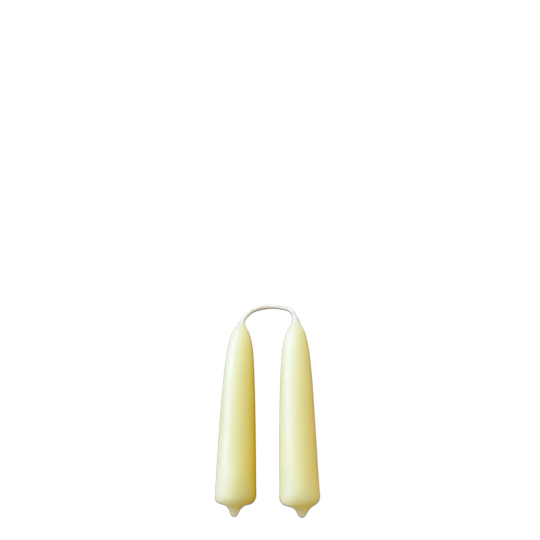 A pair of beeswax hand-dipped mini taper candles in beurre-buttery hue