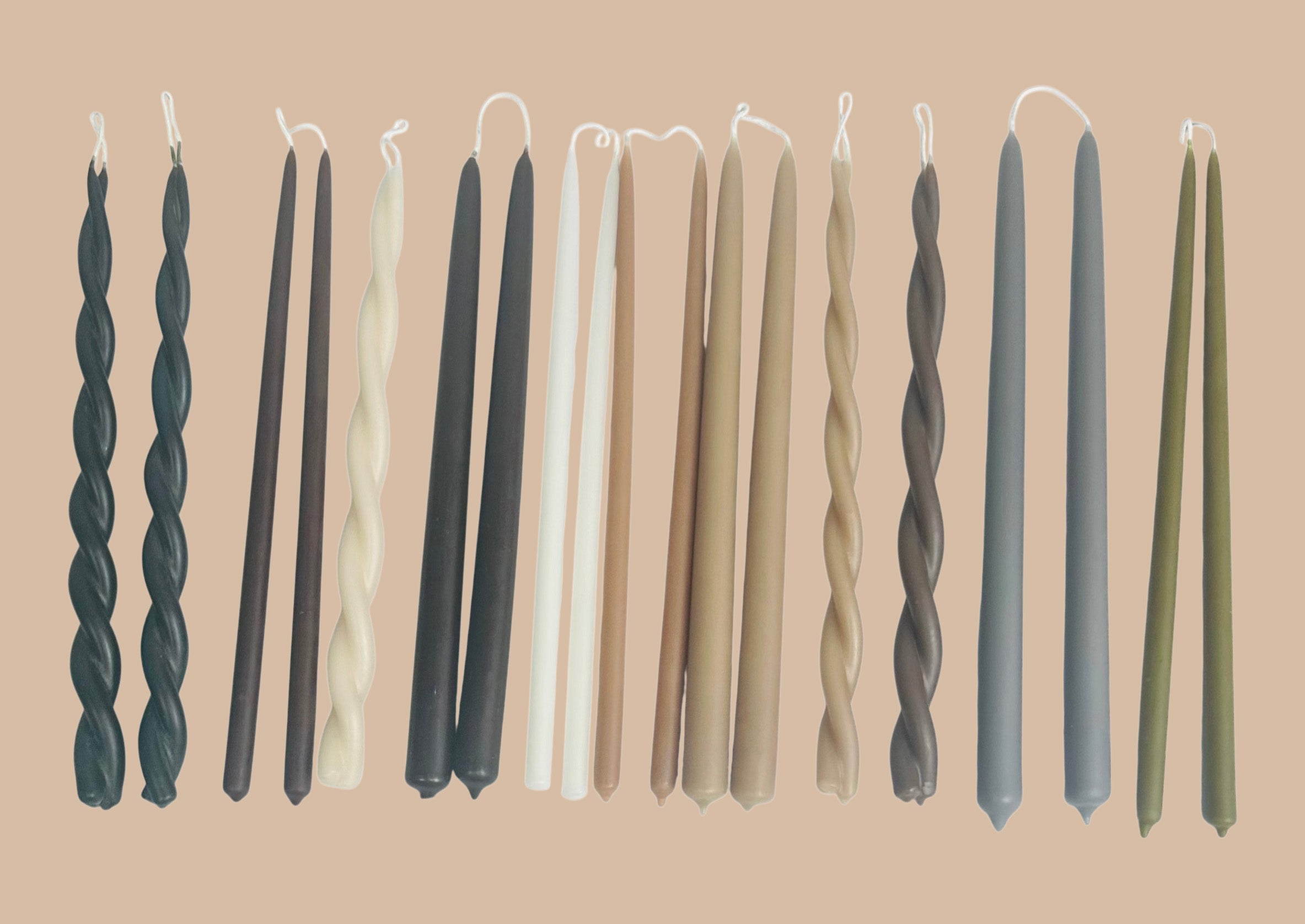 Hand-dipped GLŌAM beeswax taper candles arranged in a palette of muted autumn colors.