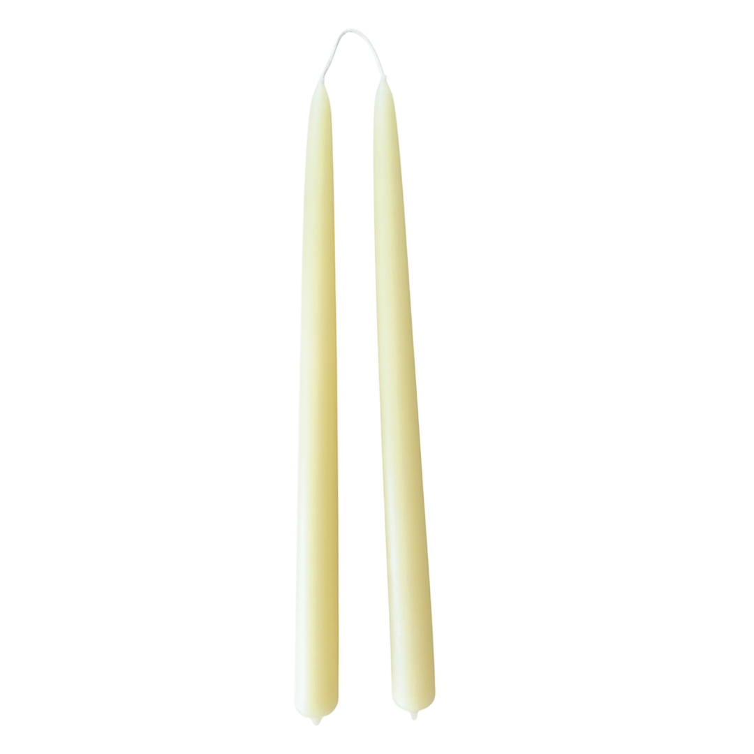 A pair of creamy-light-yellow color, in Beurre, hand-dipped beeswax taper candles made with natural plant-based pigments for an eco-friendly, non -drip, elegant home decor accent.