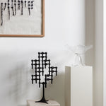 STOFF Nagel black stand built into a candle composition on a plinth in a modern interior