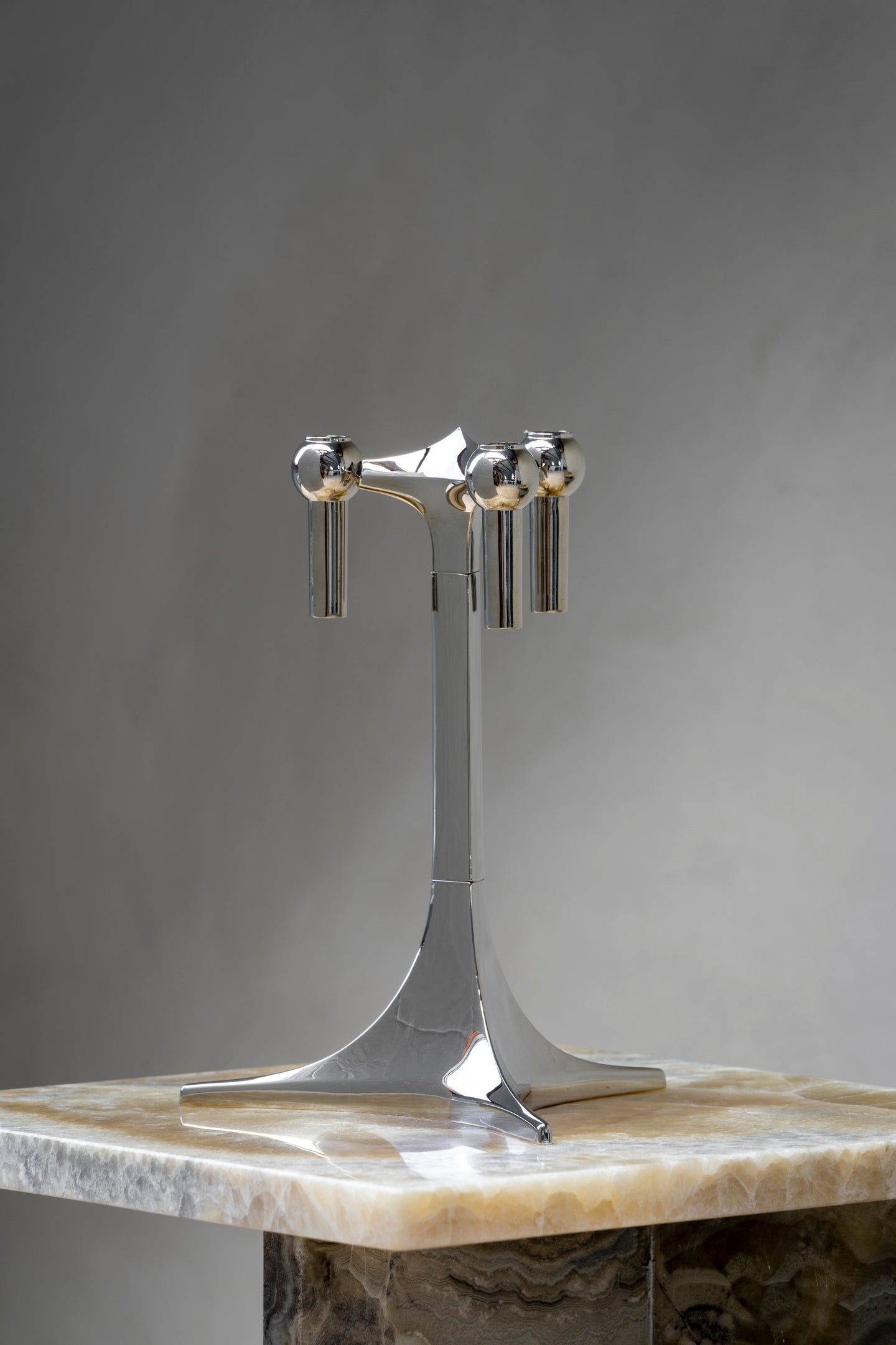 STOFF Nagel tabletop stand in chrome on a marble surface, showing the stemmed base and three candle cups